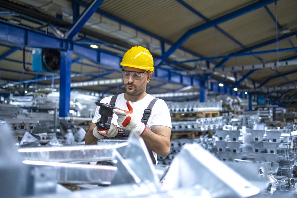Factory worker working in industrial production hall