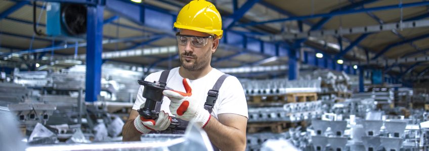 Factory worker working in industrial production hall