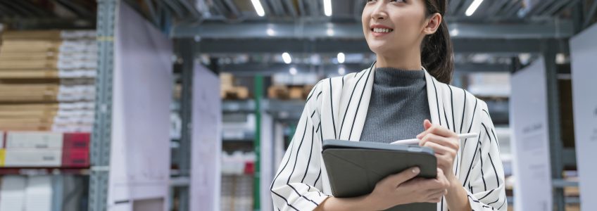 Portrait of asian woman business owner using digital tablet checking amount of stock product inventory on shelf at distribution warehouse factory.logistic business shipping and delivery service